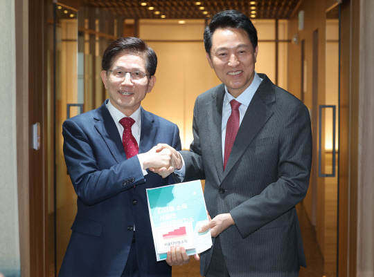 김문수(왼쪽) 전 고용노동부 장관이 16일 서울시청 시장실을 나서며 배웅 나온 오세훈 서울시장과 악수를 나누고 있다. [연합뉴스]